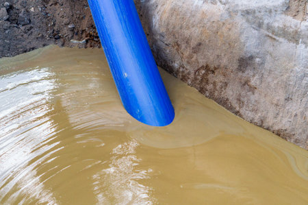 Liquid mud is pumped out of the pit through a blue pipeの写真素材