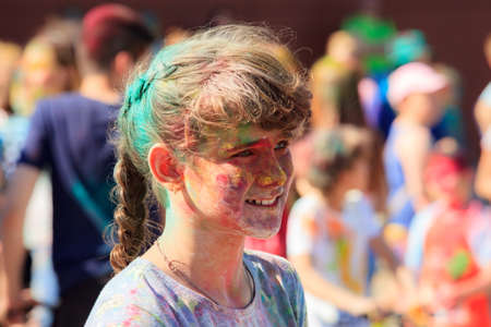 Avacado shopping center. Kostroma city. Russia. June 10, 2018 Russia. Street summer holiday colors holi. The face of a smiling girl stained with paintのeditorial素材