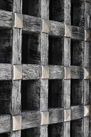 Old wooden wall of an old house in lattice pattern with rough texture.An old wooden lattice close-upの写真素材