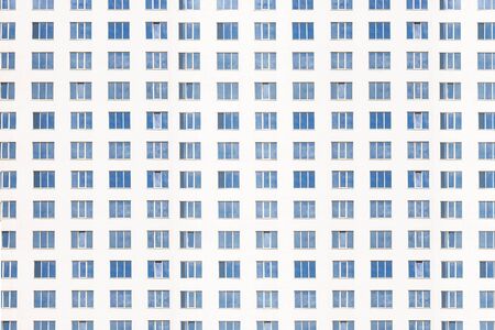 facade of office building in the evening with illuminated windowsの写真素材