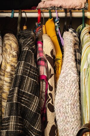 Choice of fashion clothes of different colors on wooden hangers.View of the closet with the door openの写真素材