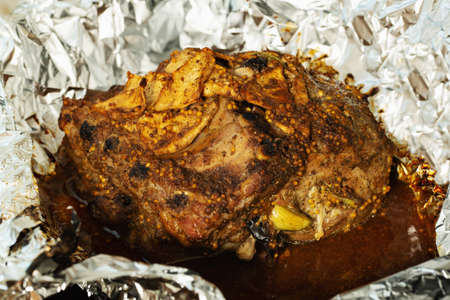 Roasted pork in the oven with spices.baked meat with spice, meat in foil,stock photo