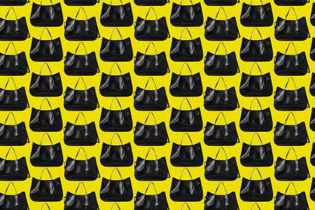 Seamless pattern of modern black shopping bags on a yellow backgroundの写真素材