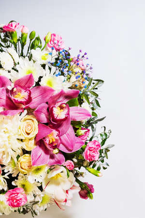 Floral bouquet of roses, carnations and orchids on white background. Close-up of a bouquet with place for textの写真素材