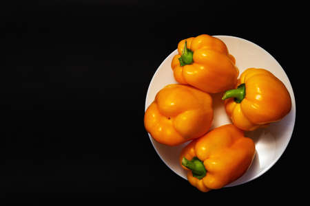 Yellow bell peppers in plate on white background top viewの写真素材
