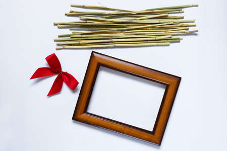 Empty wooden photo frame and red bow. Composition for Valentine's Day. Flat lay. View from above. Copy space.の写真素材