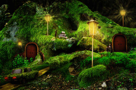 A fabulous story about a fantastic forest village of insects among mosses in the evening in the rays of lanterns. houses of wild fairy-tale heroes. Children's tale.の写真素材