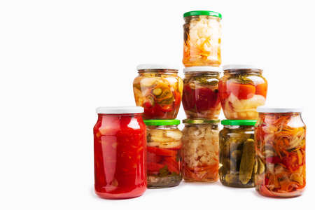Canned, pickled vegetables and food ingredients in glass jars. Preparations of various vegetables for the winter isolated on a white backgroundの写真素材