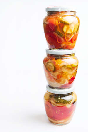 Homemade canned various vegetables with spices in glass round jarsの写真素材