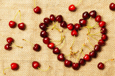 Cherry berries on fabric in the shape of a heartの写真素材