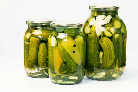 fermented vegetables. Glass jar with homemade pickled canned cucumbers of various sizes on a white background.の写真素材