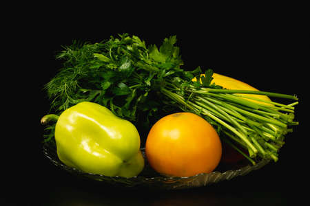Freshly picked farm vegetables with herbs in a plateの写真素材