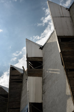 Old industrial building with concrete facade and metal decor. architecture and construction industry concept. Grunge abstraction with collapsing buildingの写真素材