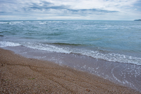 Sea with small waves and coastline on a sunny summer dayの写真素材
