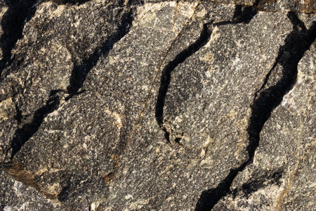 Granite surface with cracks and chips of sheer rockの写真素材