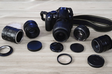 SLR camera with manual lenses and adapters on a plank surface. Amateur photography technique.の写真素材