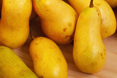A pile of yellow pears after harvest in a wooden box close-up. Market or supermarket.の写真素材