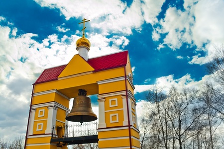 The bell of  Voskresenskiy  cathedral in Tomsk  Russia  with cross pointing to the blue cloudy skyの写真素材