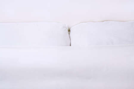 Bright high key shoot of pillows and sheet on bedの写真素材