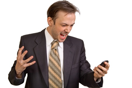 Angry businessman screams at phone isolated on white backgroundの写真素材