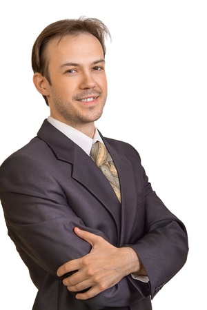 Portrait of smiling young businessman crossed arms on white backgroundの写真素材