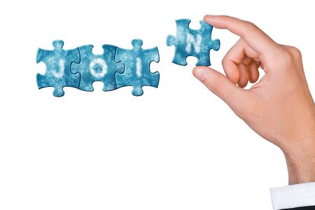 Join us now - hand connects puzzle piece with letter to build word joinの写真素材