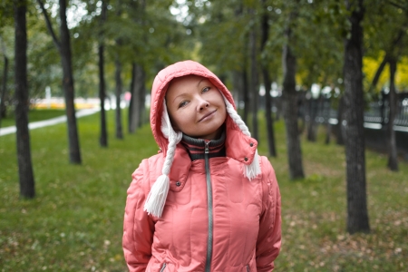 Autumn portrait of yound woman in red jacket in the parkの写真素材