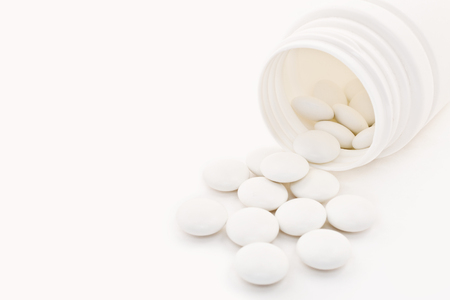 Macro shot of medical tablets with vial on white backgroundの写真素材
