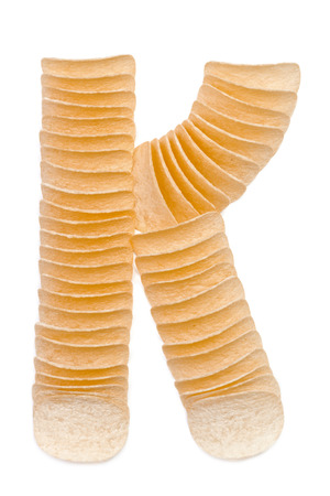 Letter K composed of chips isolated on white backgroundの写真素材