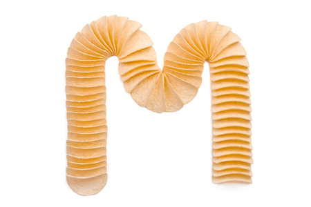 Letter M composed of chips isolated on white backgroundの写真素材