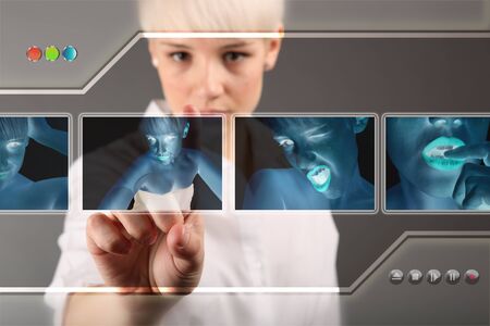 Girl choosing photo from touch screen - modern photography conceptの写真素材