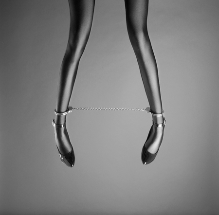 Beautiful woman legs with ankle cuffs and high heelsの写真素材