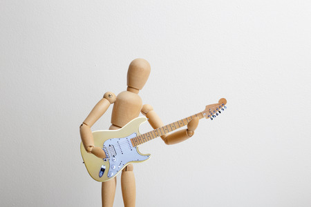 Wooden dummy posing with the electric guitarの写真素材