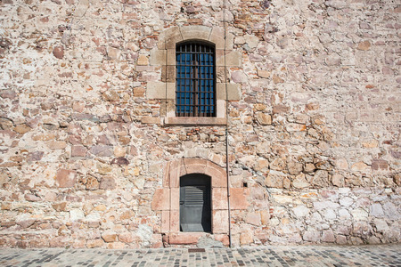 Old wall  with jail window atfortress in Barcelonaの写真素材