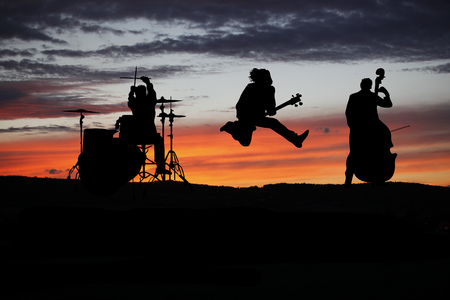 Band performing live during sunset at outside concertの写真素材
