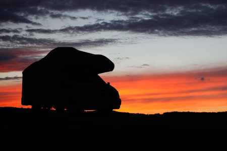 Camper recreational vehicles at sunset. Camping in nature. Holidays and travel in camper van home.の写真素材