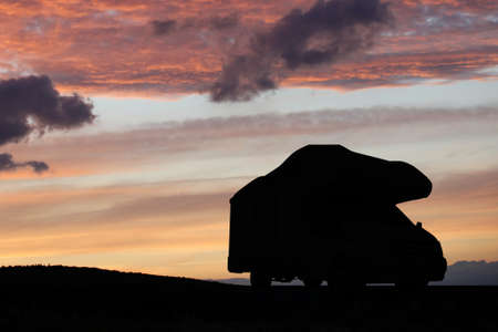 Camper recreational vehicles at sunset. Camping in nature. Holidays and travel in camper van home.の写真素材