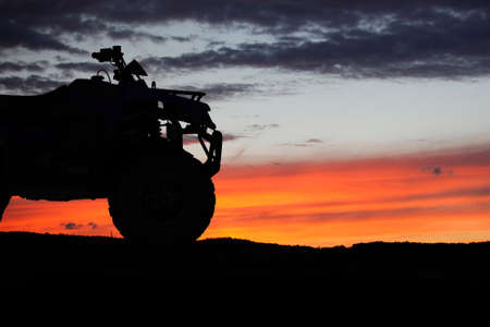 Silhouette ATV or Quad bike in the sunset. Holiday exploration concept with silhouette of quad bikeの写真素材