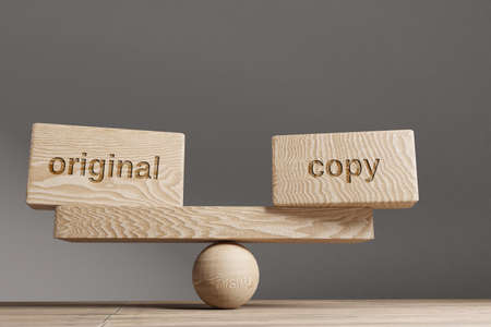 Original and copy balance concept. Wooden cube block with word Original and copy on seesaw.の写真素材