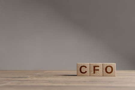 Wood cubes with acronym 'CFO' - 'Chief Fiinancial Officer' on a beautiful wooden table, studio background. Business concept with copy space.の写真素材