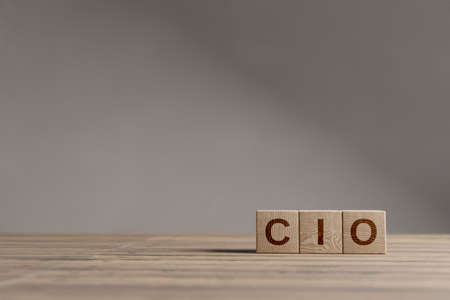 Wood cubes with acronym 'CIO' - 'Chief Information Officer' on a beautiful wooden table, studio background. Business concept with copy space.の写真素材