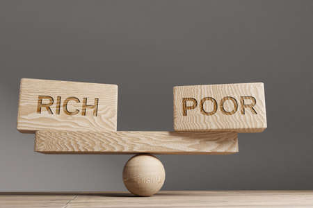 Rich and poor balance concept. Wooden cube block with word Rich and poor on seesaw.の写真素材