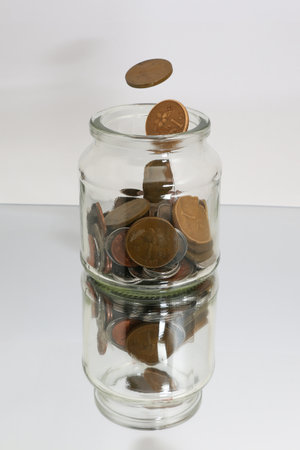 Coins in a glass jar on white background. Saving concept.の写真素材