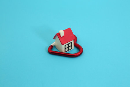 Miniature house with red heart on blue background. Love concept.の写真素材