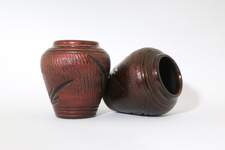 Two pottery containers with carved patterns isolated on a white background.の写真素材