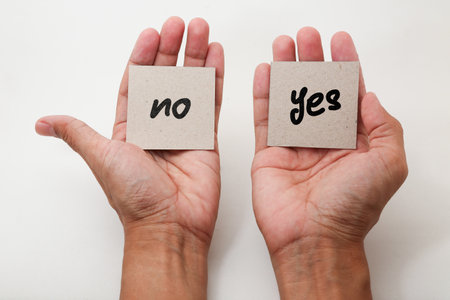Hand holding a paper card with the word no, no and yesの写真素材