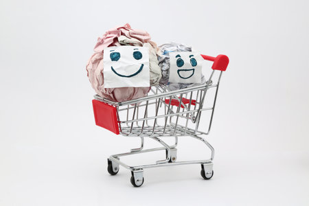 Crumpled paper ball with smiley face in shopping cart on white backgroundの写真素材