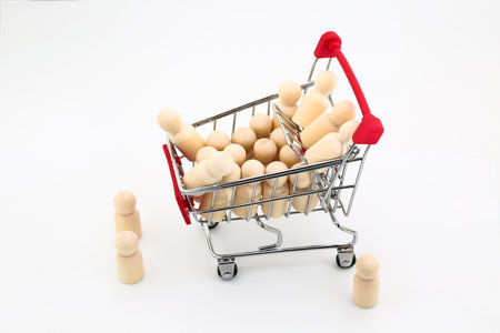 Miniature people in shopping cart on white background, business concept.の写真素材