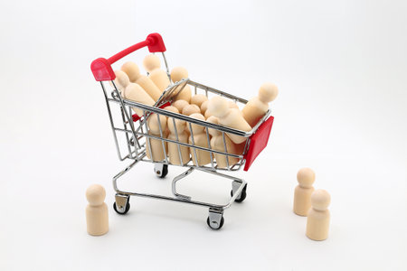 Miniature people in shopping cart on white background, business concept.の写真素材