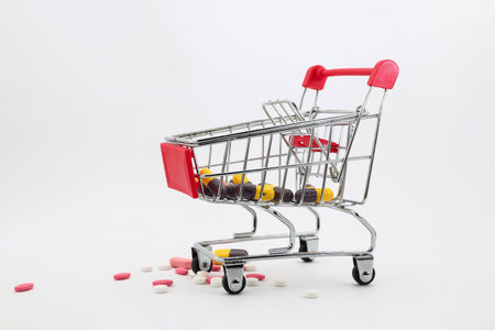 Shopping cart with colorful pills on white background.の写真素材